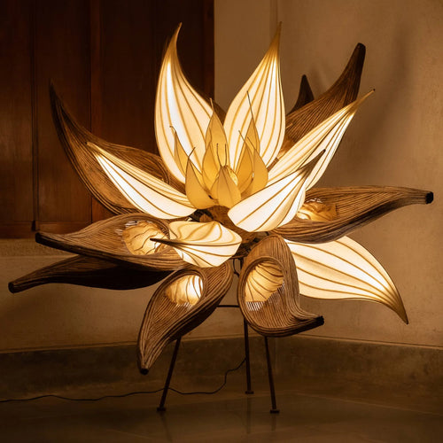 Decorative lamp shaped like a flower with warm light on a neutral background